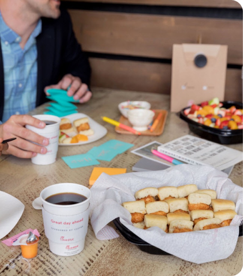 A tray of Chick-fil-A Chick-n-Minis and coffee on a table at a morning meeting.